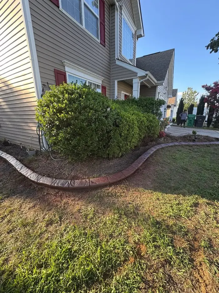Brick-edged garden landscape in front of a residential property in High Point, NC