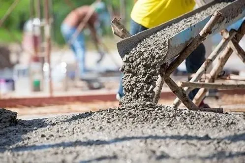 Man pouring concrete into a cement mixer during a residential concrete installation project in Greensboro, NC