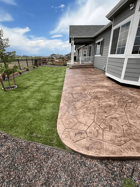 Concrete patio installation for a residential property in Kernersville, NC, surrounded by green grass and landscaping.