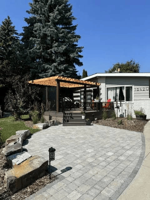Patio with a wooden pergola, outdoor furniture, and surrounding greenery creating a comfortable residential outdoor living space.