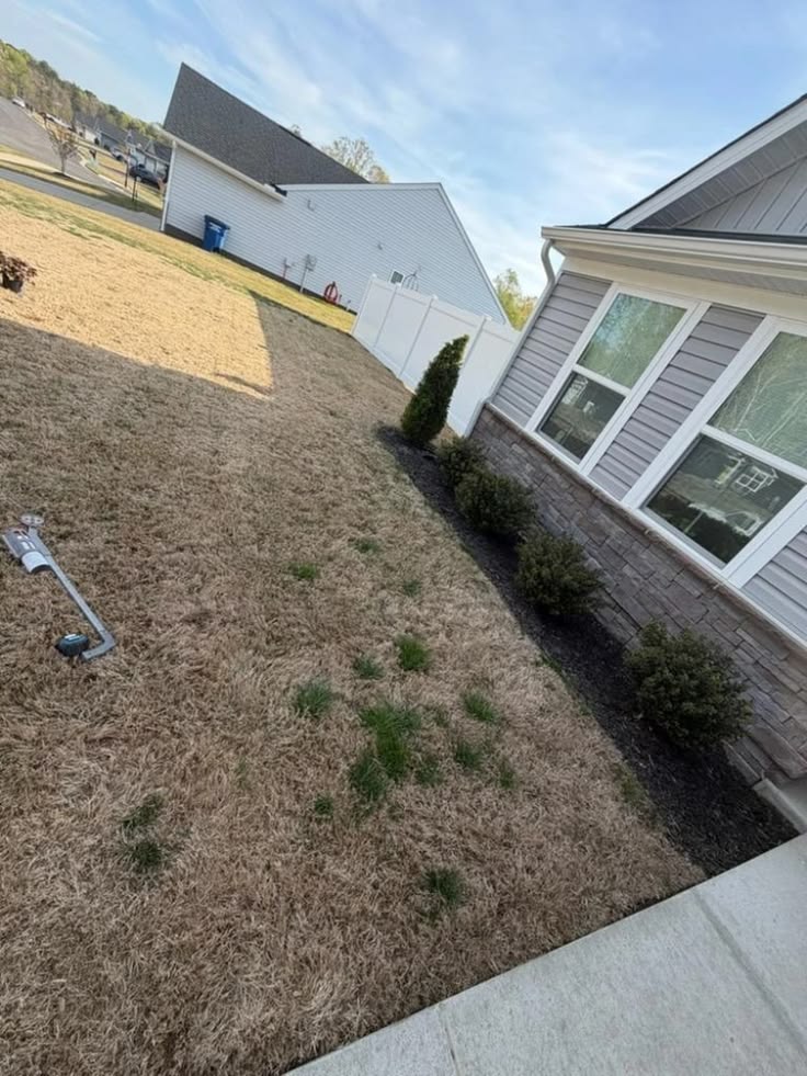 A residential lawn and front yard in Kernersville, NC requiring professional property grading and landscaping services.